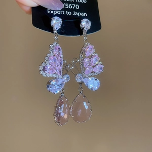 Vue détaillée des boucles d'oreilles papillon en argent avec cristaux roses en gouttes