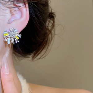 Close-up of a model wearing colorful flower stud earrings with enamel petals and crystals