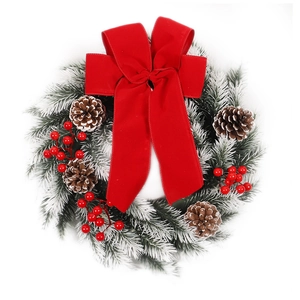Christmas wreath with red velvet bow, natural pine cones, red berries and snow-flocked needles
