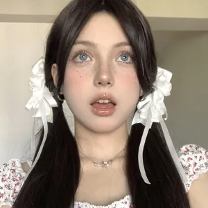 Elegant white oversized silk bow hair clip with silver pendant necklace worn by a model