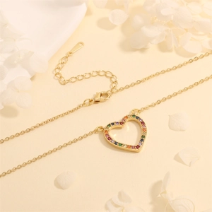 Detailed close-up of a gold heart pendant featuring vibrant rainbow cubic zirconia stones