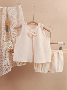 Ensemble bébé fille en gaze avec haut sans manches à nœud et short blanc crème