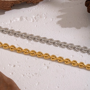 Macro shot of geometric twisted chain links in gold and silver stainless steel finish