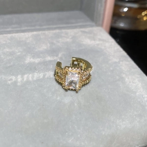 Detailed macro view of a gold-tone ear cuff set with a large emerald-cut clear zircon stone