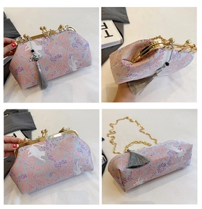 Detail view of shell bag with lavender cat patterns, gold metal frame and silk tassel
