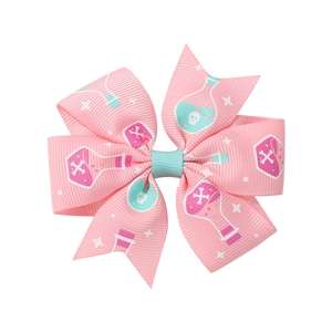 Detailed view of pink bat-themed hair clip with potion bottle and skull print pattern