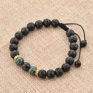 Bracelet ajustable en pierre de lave avec perles vertes et accents dorés sur toile beige