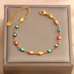 Detail of colorful evil eye enamel charms on a gold stainless steel adjustable bracelet