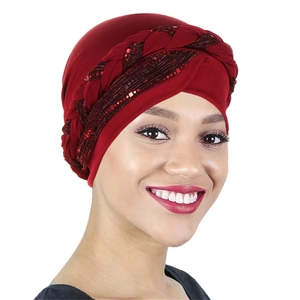 Detail of burgundy turban cap featuring a sequined braided band for a stylish look