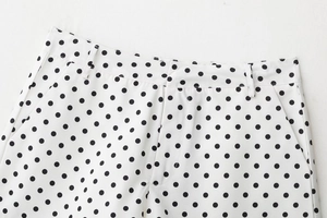 Détail du short blanc à pois avec passants de ceinture et texture des poches latérales
