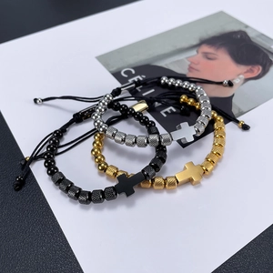 Detailed shot of beaded cross bracelets in silver, gold and black with adjustable cords