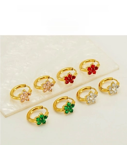 Flat lay of colorful zircon flower hoop earrings on white marble background
