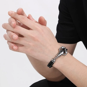 Men's braided leather bracelet featuring a large silver scorpion charm on a clean background