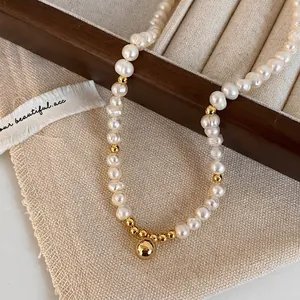Détails d'un collier de perles d'eau douce naturelles avec pendentif boule en or poli