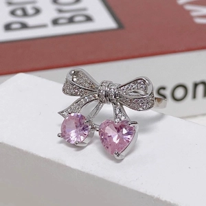 Macro detail of silver bow ring with shimmering pink heart-shaped cherry zircons
