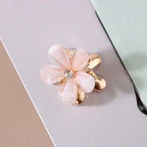 Detail of pink resin flower hair claw clip with glitter finish and center crystal accent