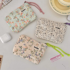 Three small floral embroidered makeup pouches in green, white and beige cotton fabric