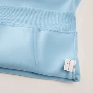 Détail du sweat à capuche bleu avec poignet côtelé et doublure en polaire douce