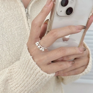 Close-up of a 925 sterling silver ring with five polished beads on a female hand