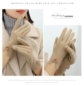 Detailed view of beige suede winter gloves with cute plush pom-pom and soft thermal lining
