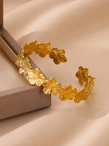 Détail macro du bracelet jonc fleuri plaqué or 18 carats aux pétales mats texturés