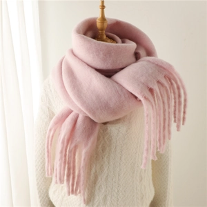 Détail d'une écharpe rose en mohair avec franges douces sur un mannequin en pull blanc