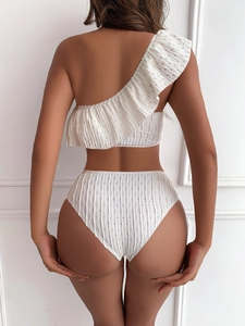 Rear view of white one-shoulder bikini featuring ruffle trim and textured dot fabric