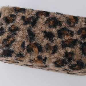 Close-up of leopard print plush fabric showing curly faux lamb wool texture on pouch