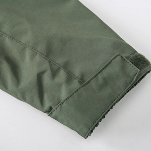 Close-up of olive green outdoor jacket featuring adjustable velcro cuffs and fine stitching