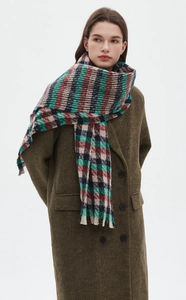Detail shot of heavy-weight plaid scarf with fringes paired with olive wool coat