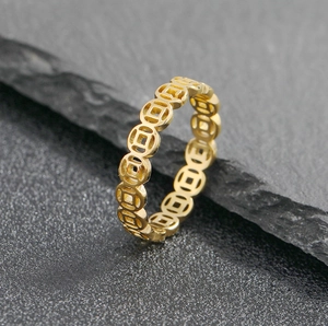 Detailed macro view of a gold lucky coin ring with ancient Chinese pattern on stone.
