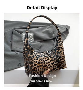 Detailed macro view of leopard print texture and metal double zippers on hobo bag