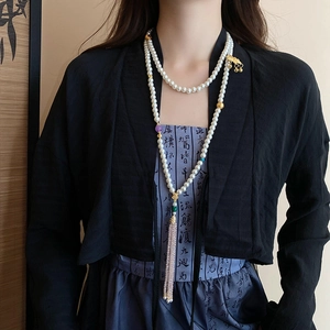 Detailed view of layered pearl necklace with golden lotus accents and pink silk tassel