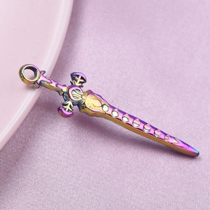 Macro view of rainbow-toned 304 stainless steel sword pendant on pink fabric