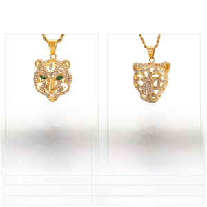 Vue détaillée de pendentifs léopard dorés avec zircons blancs et yeux en pierre verte