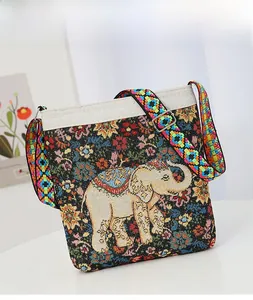 Detail of ethnic canvas bag showing elephant embroidery and woven geometric wide strap