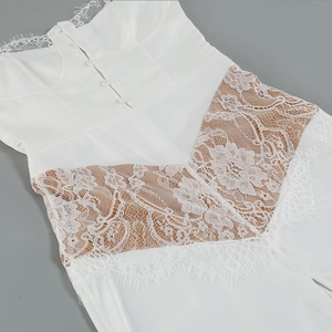 Detail of white lace stitching and front button closure on this elegant summer dress