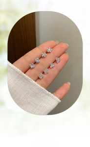 Close-up of sparkling cubic zirconia stud earrings in star, round, triangle, and square shapes