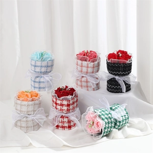 Mini soap flower bouquets in tweed wrapping with white ribbons for gift giving