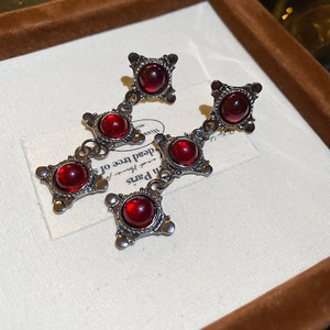 Detailed macro view of vintage Gothic resin drop earrings with dark alloy and red stones
