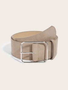 Detail of taupe wide waist belt with large silver square metal buckle on beige background