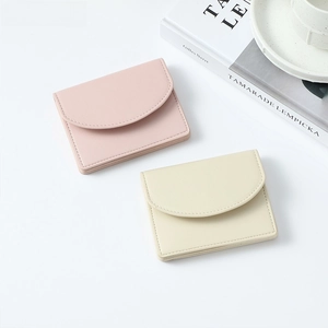Short faux leather wallets in pink and beige featuring semi-circular lids and fine stitching