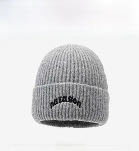 Close-up of grey knit beanie featuring black paragon embroidery and cuffed design