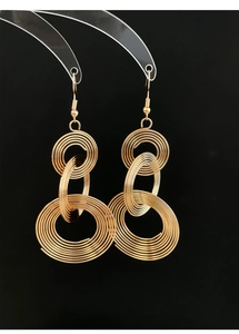 Macro shot of gold spiral multilayered concentric hoop earrings on a black background