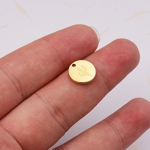 Polished 18K gold stainless steel cactus pendant held to show product scale