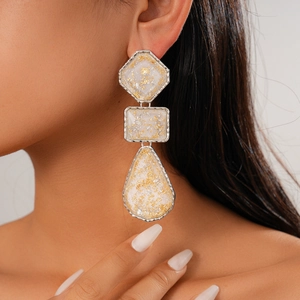 Gros plan de boucles d'oreilles géométriques en résine à trois couches sur un modèle
