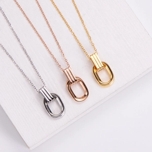 Minimalist geometric pendant necklaces in gold, silver, and rose gold on wood background