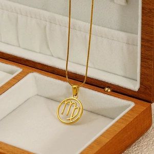 Golden Virgo zodiac hollow pendant necklace displayed on a wooden jewelry box