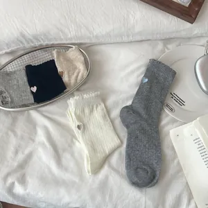 Close-up of ribbed knit cotton socks with cute heart embroidery and wavy edge details