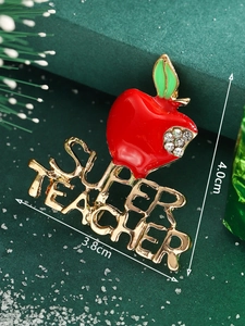 Macro shot of 4.0cm red apple Super Teacher brooch with gold letters and white rhinestones